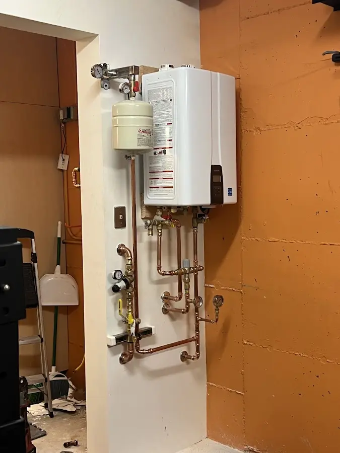 Plumbing technician inspecting water heater connections in Tellico Village